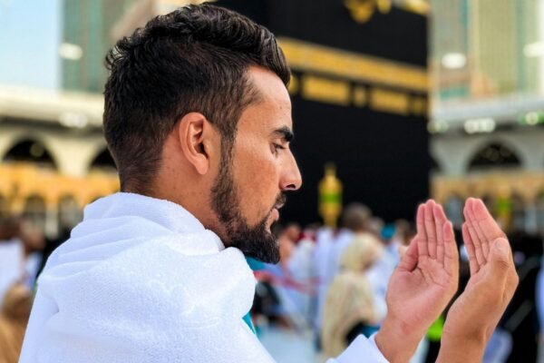 A boy praying infront of the Holy Kaaba during Umrah pilgrimage