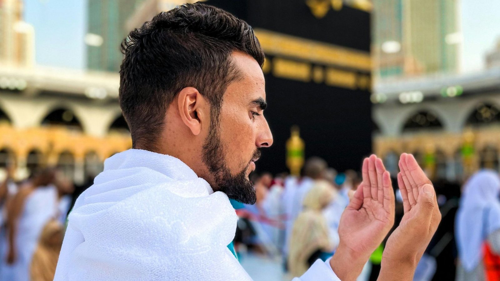 A boy praying infront of the Holy Kaaba during Umrah pilgrimage